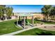 Modern playground with slide, climbing structures, and covered picnic area, surrounded by lush landscaping at 42735 W Bravo Dr, Maricopa, AZ 85138