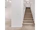 Carpeted staircase featuring neutral tones and white risers at 42735 W Bravo Dr, Maricopa, AZ 85138