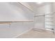 Spacious walk-in closet with wood rods and shelving for storage at 42735 W Bravo Dr, Maricopa, AZ 85138
