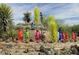 Whimsical desert garden featuring vibrant glass sculptures interspersed with native plants, creating a unique artistic landscape at 4306 E Flower St, Phoenix, AZ 85018