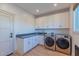 Well-equipped laundry room with modern appliances, ample storage, and a practical design at 4306 E Flower St, Phoenix, AZ 85018