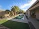 The backyard offers a serene pool, covered patio, and desert landscaping at 43486 W Mccord Dr, Maricopa, AZ 85138