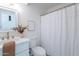 Bright bathroom with a vanity featuring a marble countertop, fresh flowers, and a shower with curtain at 4731 N 26Th Ln, Phoenix, AZ 85017
