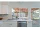 White kitchen with stainless steel appliances, stone countertops and backsplash, and backyard view at 4731 N 26Th Ln, Phoenix, AZ 85017