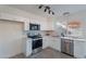 Bright kitchen with stainless steel appliances, white cabinets, tile backsplash, and backyard views at 4731 N 26Th Ln, Phoenix, AZ 85017