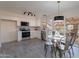 Bright kitchen with stainless steel appliances, white cabinets, tile backsplash, and adjacent dining area at 4731 N 26Th Ln, Phoenix, AZ 85017