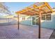 View of the backyard brick patio with the sliding glass door and pergola with a backyard at 4731 N 26Th Ln, Phoenix, AZ 85017