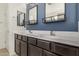 Modern bathroom featuring double sinks with dark wood cabinets and a large mirror at 5345 W Leodra Ln, Laveen, AZ 85339
