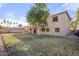 Expansive backyard featuring a covered patio, a mature tree, and ample space for outdoor activities at 5422 W Bryce Ln, Glendale, AZ 85301