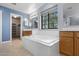 Bathroom with a soaking tub, wood cabinets, a large window, and views to the walk-in closet at 5422 W Bryce Ln, Glendale, AZ 85301