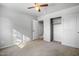 This bedroom has neutral carpet, a spacious closet, and a ceiling fan at 5422 W Bryce Ln, Glendale, AZ 85301