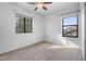 Bright bedroom with neutral carpet, two windows, and closet space at 5422 W Bryce Ln, Glendale, AZ 85301