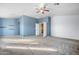 Spacious bedroom with neutral carpeting, light blue accent wall, and an open doorway at 5422 W Bryce Ln, Glendale, AZ 85301