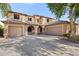 Inviting two-story home showcasing a three-car garage and a charming front entrance with arched accents at 5422 W Bryce Ln, Glendale, AZ 85301