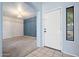 Welcoming foyer with a white front door and a view into a carpeted living area with blue accent wall at 5422 W Bryce Ln, Glendale, AZ 85301