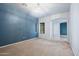 An empty living room features a blue accent wall and arched entrance ways for seamless flow at 5422 W Bryce Ln, Glendale, AZ 85301