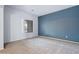 An empty living room features a blue accent wall and a window with natural light at 5422 W Bryce Ln, Glendale, AZ 85301