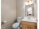 A half-bathroom with a toilet, wood vanity, and framed mirror over the sink at 6353 S Eagle Ct, Gold Canyon, AZ 85118