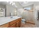 Bright bathroom featuring a glass block shower, tile flooring, and a wooden vanity with sink at 6353 S Eagle Ct, Gold Canyon, AZ 85118