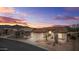 Charming single-story home featuring desert landscaping, a tile roof, and a two-car garage against a colorful dusk sky at 6353 S Eagle Ct, Gold Canyon, AZ 85118