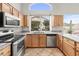 Well-lit kitchen with stainless steel appliances, light wood cabinets, and granite countertops at 6353 S Eagle Ct, Gold Canyon, AZ 85118