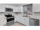 Bright kitchen featuring stainless steel appliances and white cabinetry, plus quartz countertops at 681 E Los Arboles Pl, Chandler, AZ 85225