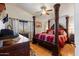 Primary bedroom features a four poster bed, hardwood floors, and stylish decor at 8736 W Kathleen Rd, Peoria, AZ 85382
