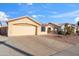 Front exterior view featuring the home's large driveway, two-car garage, and desert-friendly landscaping at 8736 W Kathleen Rd, Peoria, AZ 85382