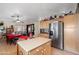 Bright kitchen with stainless steel refrigerator, island, and wooden cabinets at 8736 W Kathleen Rd, Peoria, AZ 85382