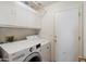 Convenient laundry room with modern washer/dryer and overhead cabinet storage at 8736 W Kathleen Rd, Peoria, AZ 85382