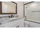 Bright bathroom with a granite countertop vanity and a glass-enclosed shower-over-tub at 8743 E Rose Ln, Scottsdale, AZ 85250