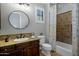 Charming bathroom featuring a shower-tub combination, stylish vanity with granite top, and shuttered window at 9412 E Hidden Spur Trl, Scottsdale, AZ 85255