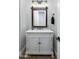 Stylish half bathroom vanity with farmhouse-style mirror, light fixture, and sink at 9412 E Hidden Spur Trl, Scottsdale, AZ 85255