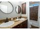 Elegant bathroom boasts dual sinks, granite countertops, dark wood cabinetry, and a tiled shower at 9412 E Hidden Spur Trl, Scottsdale, AZ 85255
