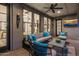 Inviting covered patio with a ceiling fan, comfortable seating, outdoor television and stylish decor at 9412 E Hidden Spur Trl, Scottsdale, AZ 85255