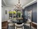 Dining room with dark accent wall, a modern chandelier and access to an outdoor space at 9412 E Hidden Spur Trl, Scottsdale, AZ 85255