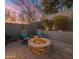 A cozy outdoor fire pit area with comfortable seating, cacti and a view of the landscaped yard at 9412 E Hidden Spur Trl, Scottsdale, AZ 85255