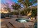 Relaxing backyard hot tub with a stone surround, landscaping, and nearby fire pit at 9412 E Hidden Spur Trl, Scottsdale, AZ 85255