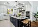 Bright kitchen features white cabinets, black island, marble countertops, stainless appliances and a large island at 9412 E Hidden Spur Trl, Scottsdale, AZ 85255
