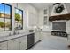 Bright kitchen features white cabinets, stainless steel appliances, marble countertops, and modern fixtures at 9412 E Hidden Spur Trl, Scottsdale, AZ 85255