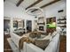 Open living room featuring beamed ceilings, stone fireplace, large windows and comfortable seating at 9412 E Hidden Spur Trl, Scottsdale, AZ 85255