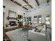 Spacious living room featuring a stone fireplace, beamed ceilings, large windows and a large chandelier at 9412 E Hidden Spur Trl, Scottsdale, AZ 85255