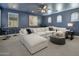 Spacious living room featuring a large sectional sofa, arched windows, stylish decor, and a wet bar at 9412 E Hidden Spur Trl, Scottsdale, AZ 85255