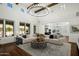 Open concept space with wood beams, chandelier, large windows, and comfortable seating at 9412 E Hidden Spur Trl, Scottsdale, AZ 85255