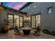 Paver patio with a cozy fire pit, outdoor seating, ambient string lights, and desert landscaping at 9412 E Hidden Spur Trl, Scottsdale, AZ 85255