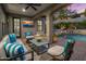Outdoor living area with comfortable seating, overlooking a stunning pool and landscape at dusk at 9412 E Hidden Spur Trl, Scottsdale, AZ 85255