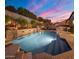 A luxurious pool with stone accents, a built-in grill, and outdoor seating, perfect for relaxing at 9412 E Hidden Spur Trl, Scottsdale, AZ 85255