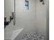 Sleek shower featuring speckled quartz walls, mosaic tile floor, bench seating, and modern black fixtures at 9412 E Hidden Spur Trl, Scottsdale, AZ 85255