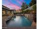 A beautiful backyard swimming pool with attached spa, water feature, and lush landscaping at 9412 E Hidden Spur Trl, Scottsdale, AZ 85255