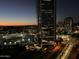 Evening cityscape view with an illuminated high-rise building at dusk and a glowing sunset in the distance at 1 E Lexington Ave # 1210, Phoenix, AZ 85012